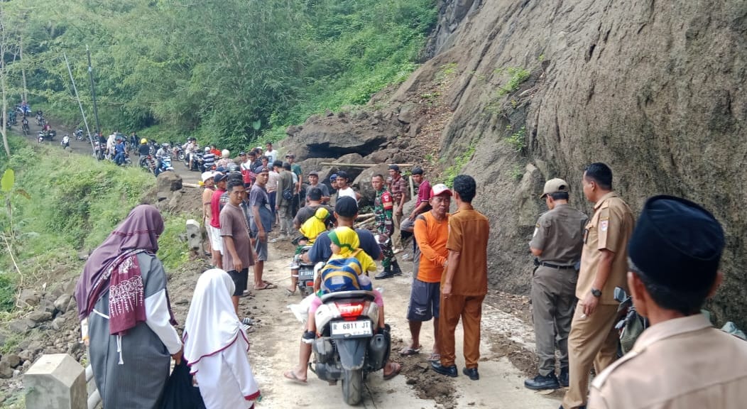 Petugas gabungan dan warga saat kerja bakti membersihkan material longsor yang menutupi jalan di Desa Bantarmangu, Cimanggu, Cilacap. (Pendim Cilacap).