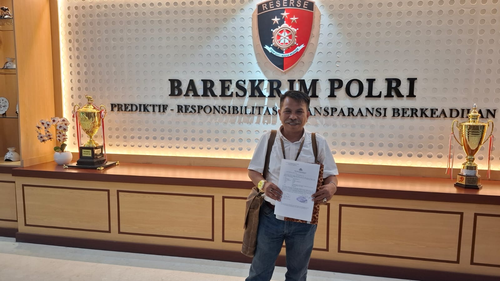 Advokat H. Djoko Susanto, SH memperlihatkan dokumen laporan resmi di Bareskrim Polri, Selasa (06/01/2026).